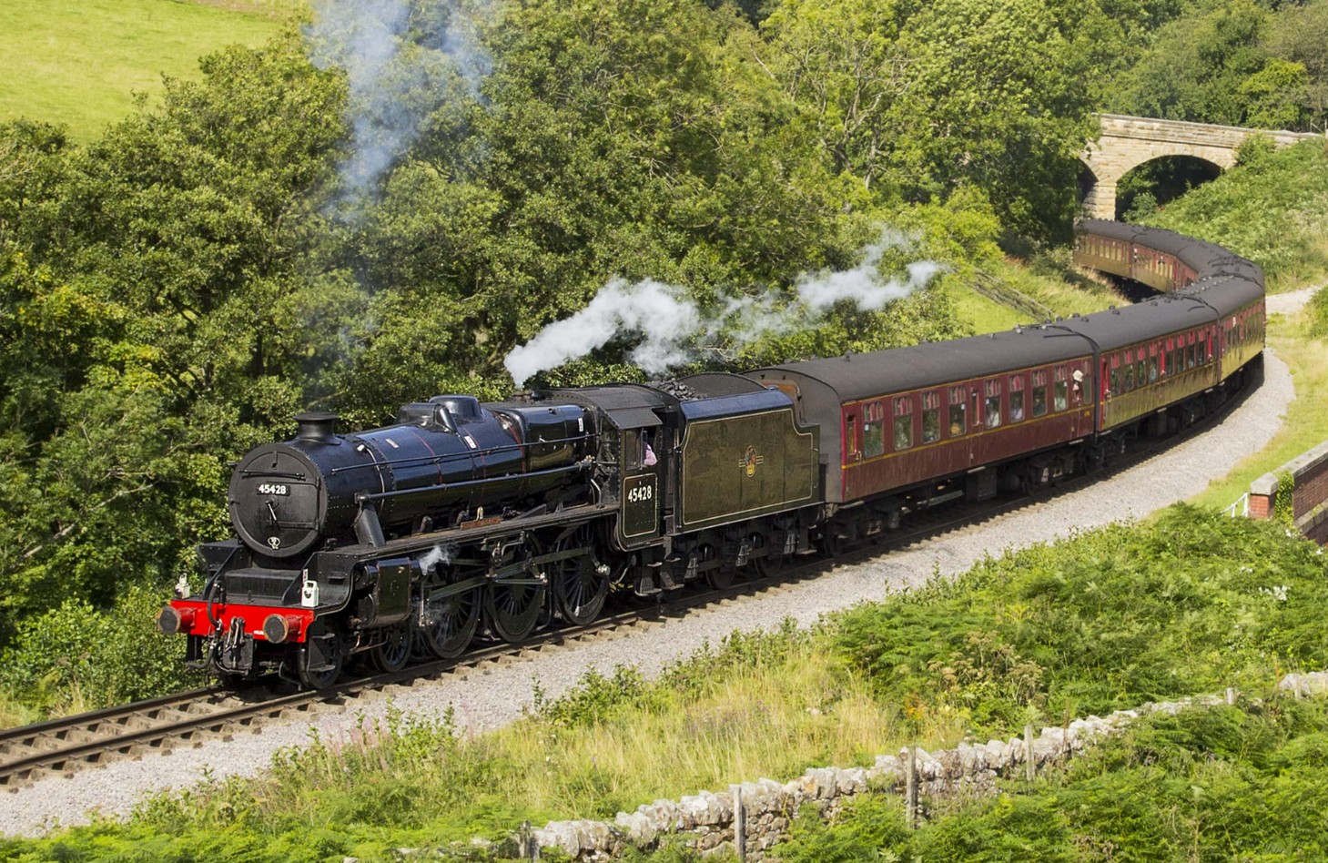 LMS Black Five steam locomotive 45428 rounding the curve with maroon carriages on the North Yorkshire Moors Railway