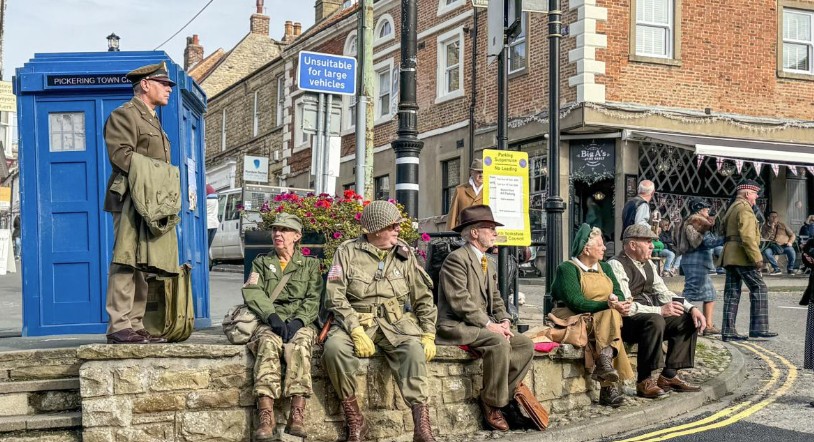 Wartime re-enactors in 1940s uniform beside the blue police box in Pickering town centre during the Wartime Weekend