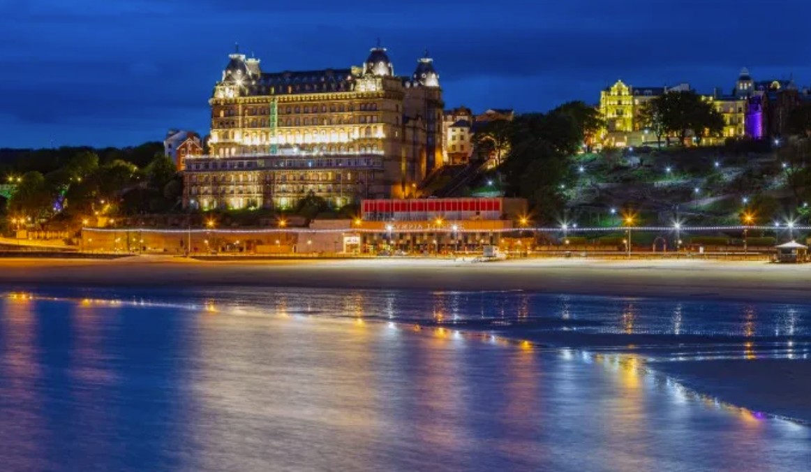 Scarborough South Bay at dusk, with the illuminated Grand Hotel reflected on the wet sand