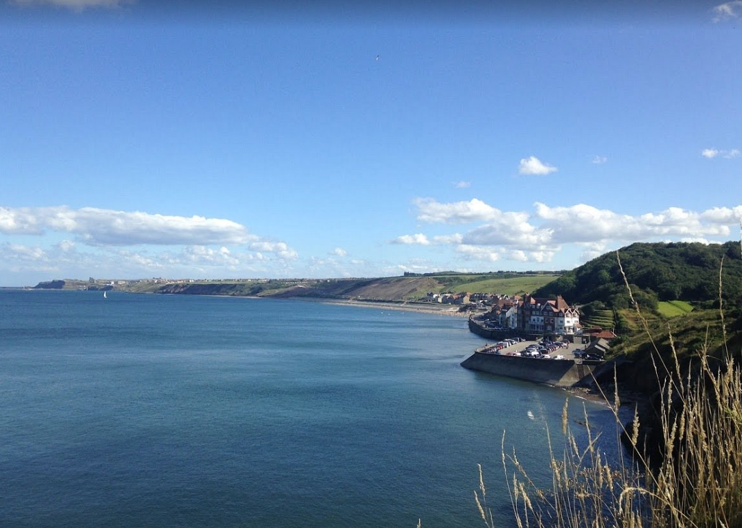 The coast at Sandsend, with the beach running away beneath green cliffs