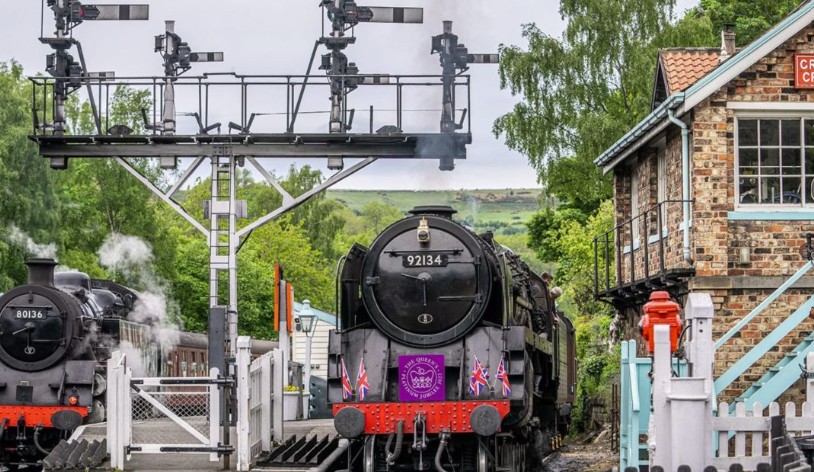 Steam locomotive 92134 framed beneath the signal gantry at Goathland station on the North Yorkshire Moors Railway