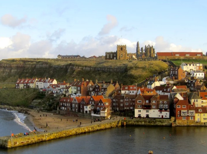 Whitby old town, harbour and beach with St Mary's Church and Whitby Abbey on the East Cliff