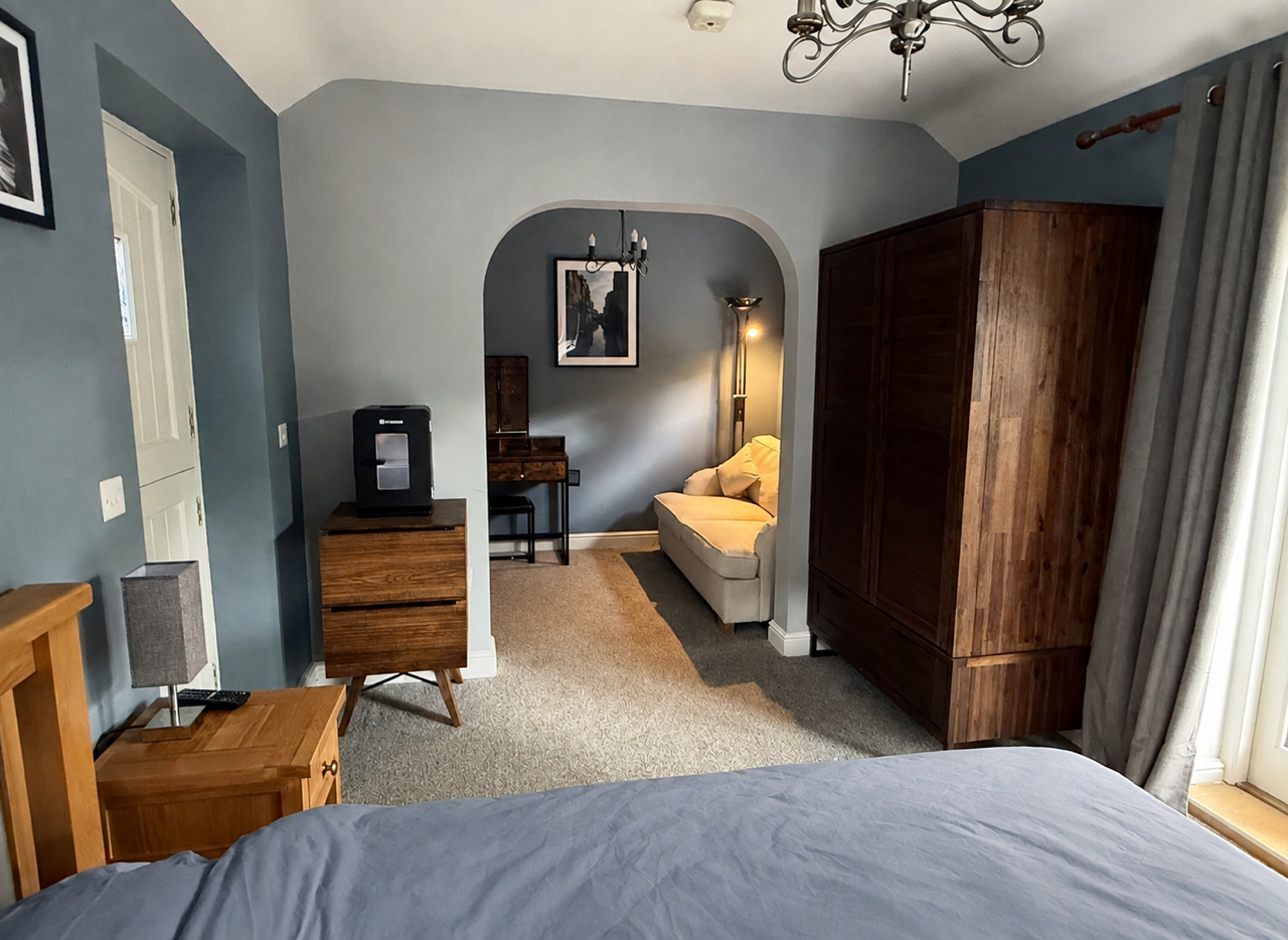 Bedroom at Allerston Cottage with oak furniture, a dark wood wardrobe and a seating alcove
