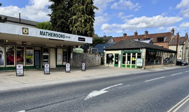 The Mathewsons.co.uk showroom and green-fronted Mathewsons Auctioneers office on the main road through Thornton-le-Dale on a sunny day
