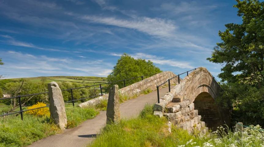 The old stone arch of Duck Bridge crossing the River Esk near Danby