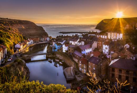 Staithes harbour and tightly packed village cottages at sunset