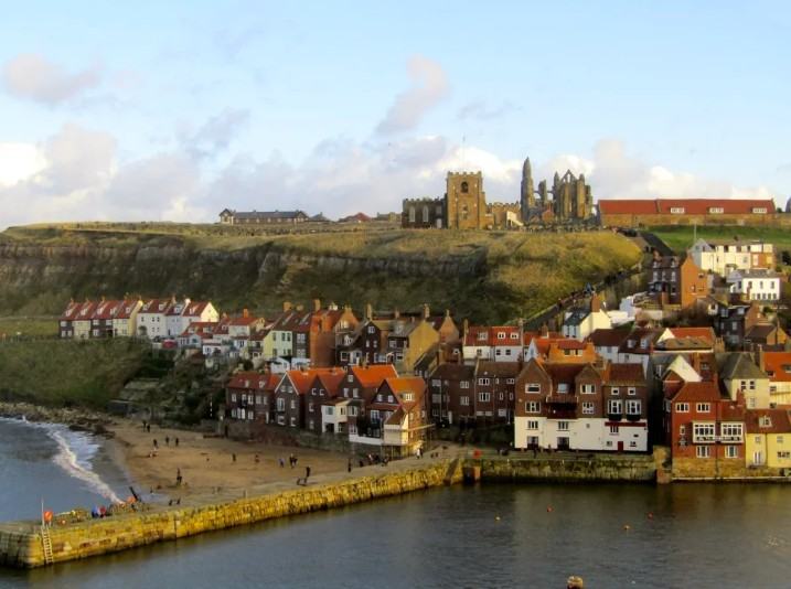 Whitby old town, harbour and beach with St Mary's Church and Whitby Abbey on the East Cliff